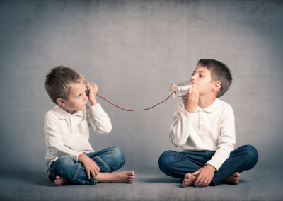 Young brothers talking with tin can telephone on grunge backgrou