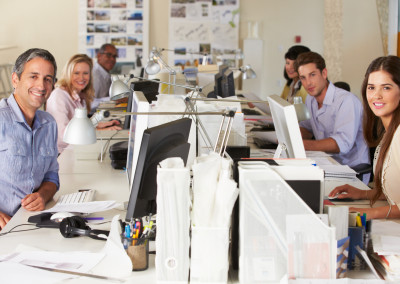 Team Working At Desks In Busy Office